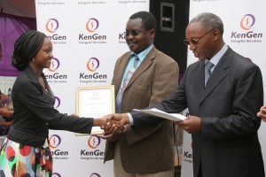 Mary Nyambura (left) shakes hands with KenGen Ag.Managing Director/CEO Simon Nguri (right) as she receives her University Scholarship from senior official, Ministry of Energy Mr.John Omenge. Mary Nyambura scored an A with 83 points in lasts year’s KCSE. 