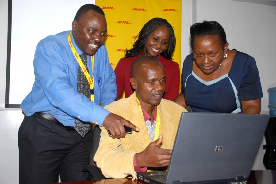 (Seated) Mr. Peter Kuya showcasing the computer to Mr. Kenneth Kaunda HR DHL Express, Eva Ntalani Program Manager Zawadi Africa Education Fund- Kenya and Mrs. Anne Kyoya Executive Director Zawadi Educational fund