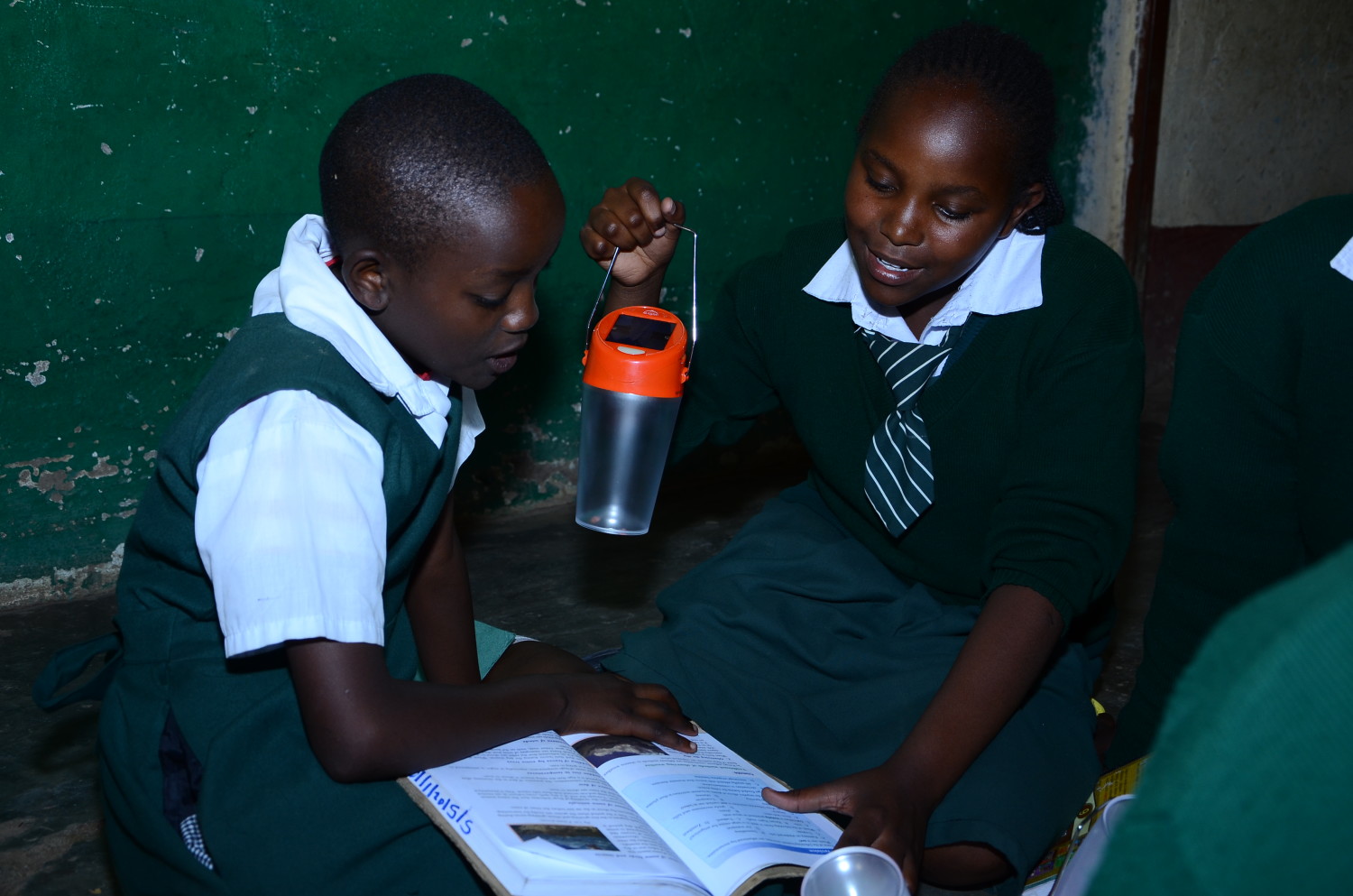 Anne Mueni and Jane Ndunge of St. Mary's Tala Primary School use solar powered light to have an evening group discussion
