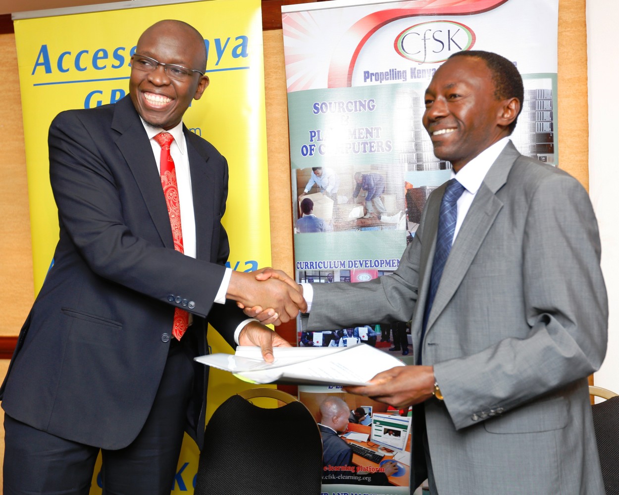 Kris Senanu Deputy Chief Executive AccessKenya Group and Dr. Tom Musili, Executive Director Computer for Schools Kenya exchange documents after signing an Memorandum of Understanding that will see AccessKenya fund the training of 200 principals on the use of technology in classrooms at a cost of Kes 1.2 million this year